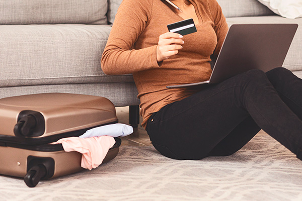 Mujer cancelando un viaje a través de una laptop